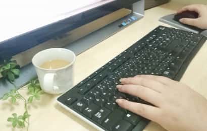 パソコンのキーボードを操作する女性の手元