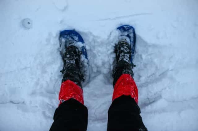 雪の上に立つ足カバーを付けた人の脚