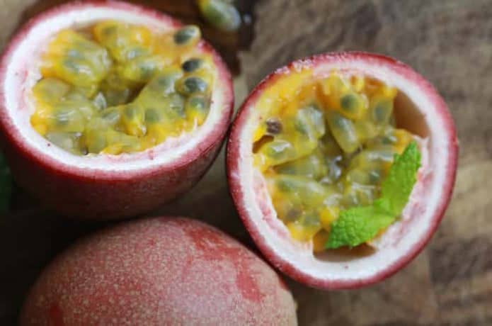 パッションフルーツを切ると、中から鮮やかな黄色の果肉があらわれる