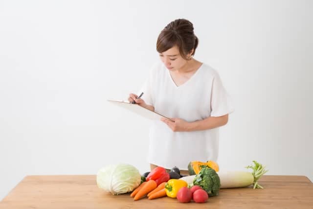 野菜を見て勉強する女性