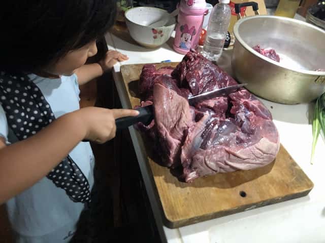 イノシシ肉を切る女の子